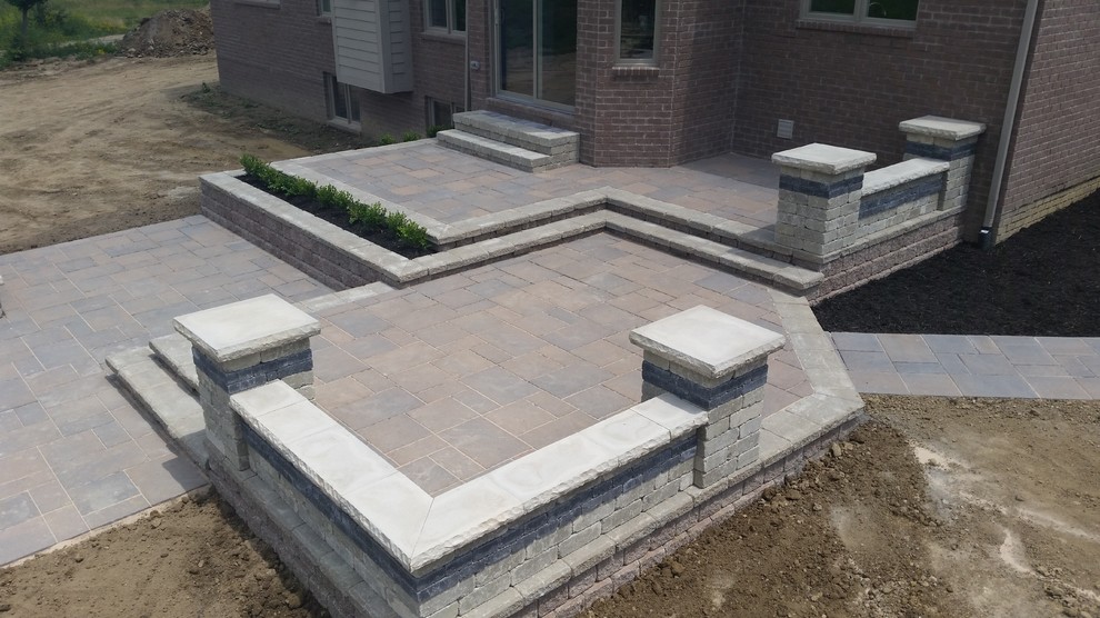 Photo of a large arts and crafts backyard patio in Detroit with a fire feature, brick pavers and no cover.
