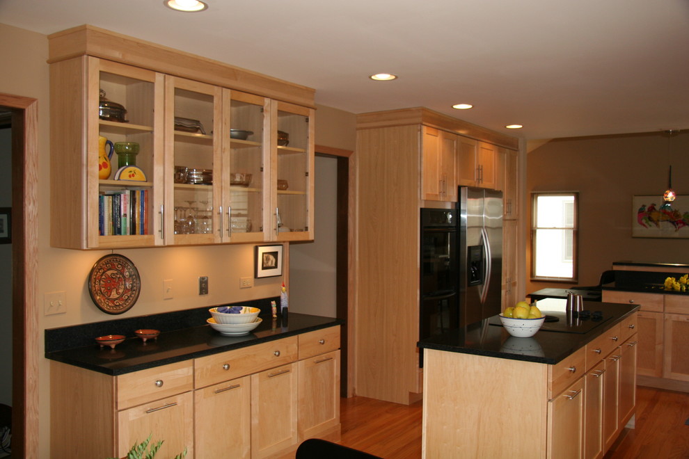 Mid-sized minimalist u-shaped light wood floor eat-in kitchen photo in Chicago with an undermount sink, shaker cabinets, light wood cabinets, granite countertops, orange backsplash, black appliances and an island