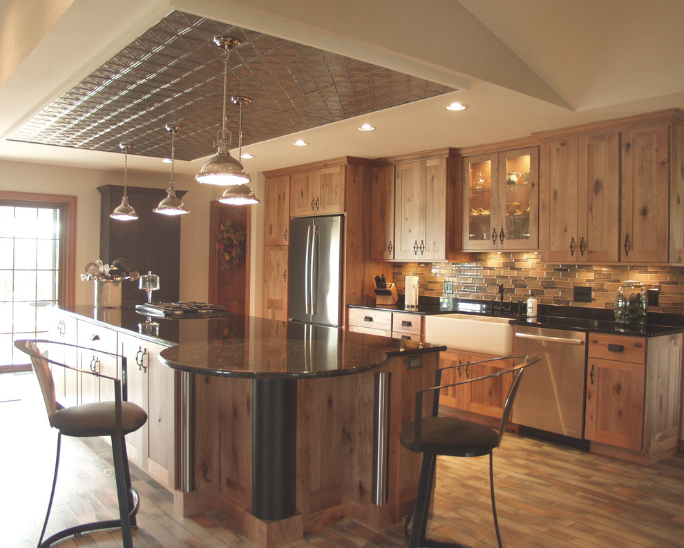 Mountain style kitchen photo with flat-panel cabinets, light wood cabinets, granite countertops, stainless steel appliances and an island