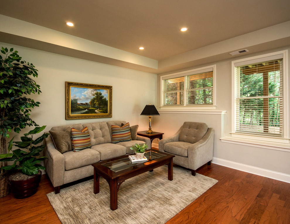 This is an example of a mid-sized traditional walk-out basement in Atlanta with beige walls, dark hardwood floors, no fireplace and orange floor.