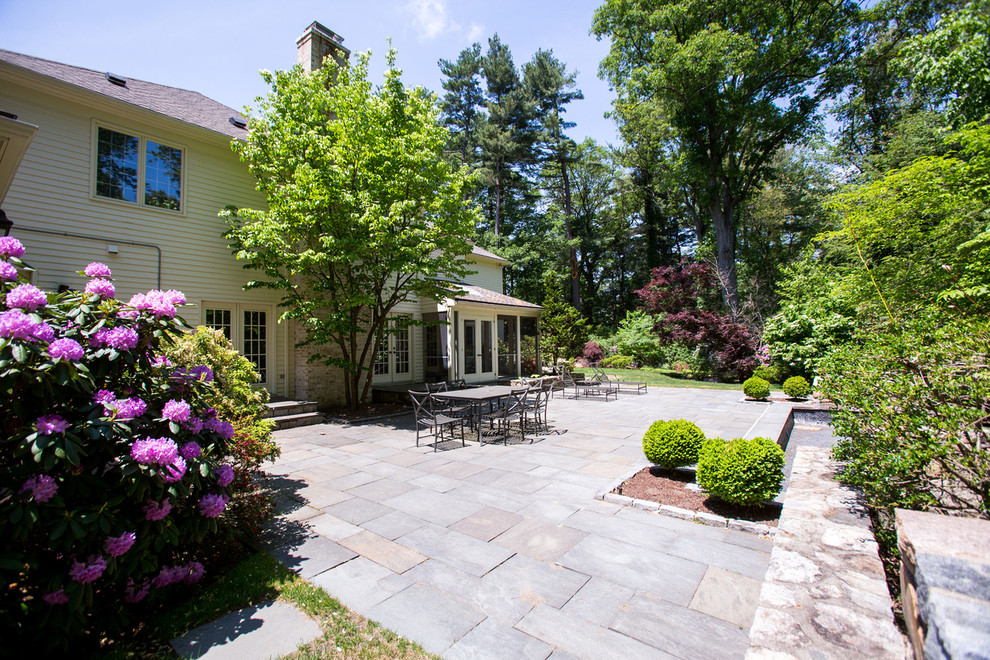 Photo of a contemporary patio in Boston with natural stone pavers.