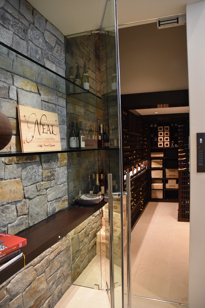 This is an example of a large contemporary wine cellar in Los Angeles with ceramic floors and display racks.