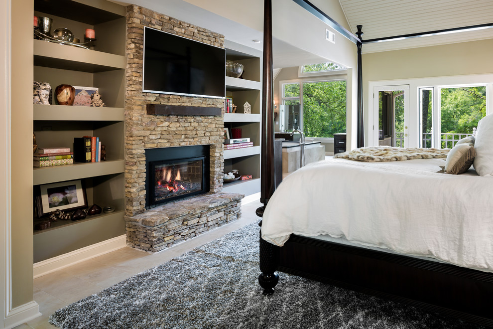 This is an example of an expansive eclectic master bedroom in Atlanta with beige walls, ceramic floors, a standard fireplace and a stone fireplace surround.