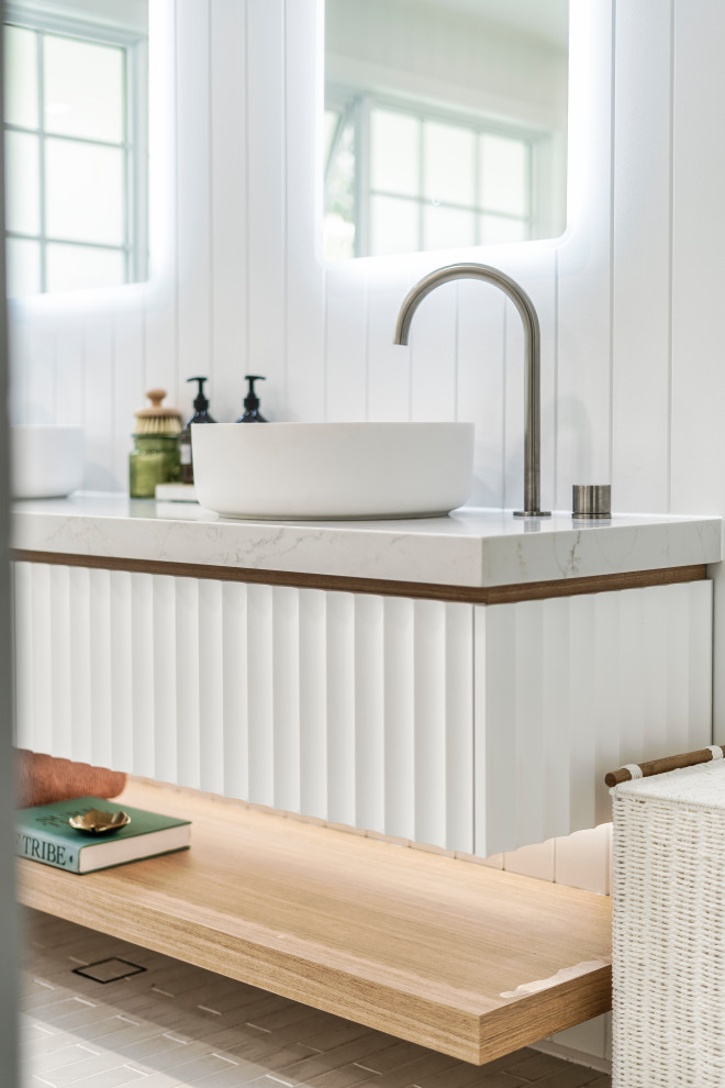 This is an example of a mid-sized mediterranean kids bathroom in Gold Coast - Tweed with furniture-like cabinets, white cabinets, a freestanding tub, an open shower, a one-piece toilet, white tile, porcelain tile, white walls, porcelain floors, a vessel sink, engineered quartz benchtops, white floor, an open shower, white benchtops, an enclosed toilet, a floating vanity and planked wall panelling.