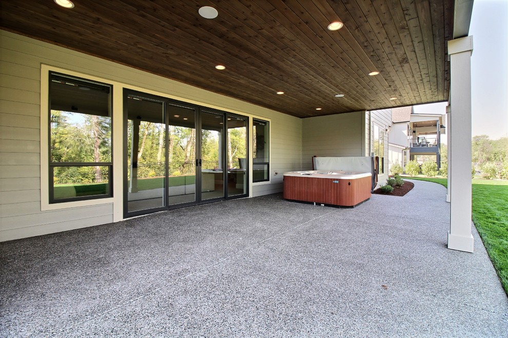 Photo of an expansive arts and crafts backyard patio in Portland with concrete slab and a roof extension.
