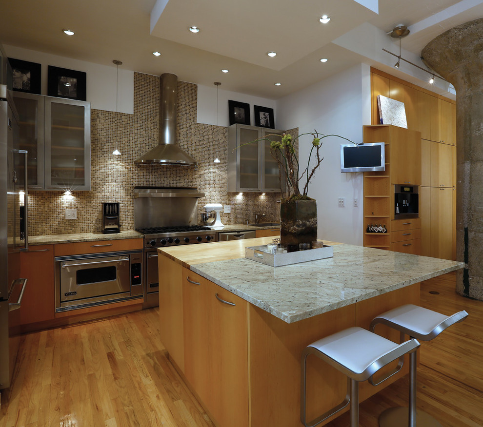 Photo of a contemporary l-shaped kitchen in New York with flat-panel cabinets, light wood cabinets, grey splashback, mosaic tile splashback and stainless steel appliances.