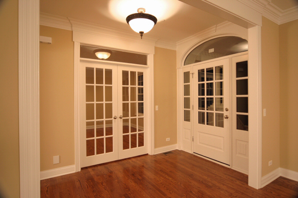 This is an example of a mid-sized traditional foyer in Chicago with beige walls, medium hardwood floors, a single front door and a white front door.
