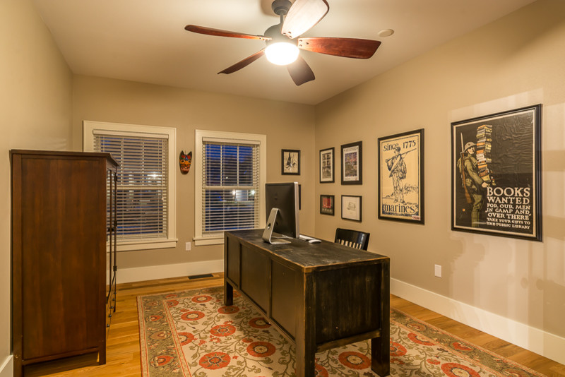 Mid-sized transitional home studio in Cedar Rapids with beige walls, medium hardwood floors, no fireplace and a freestanding desk.