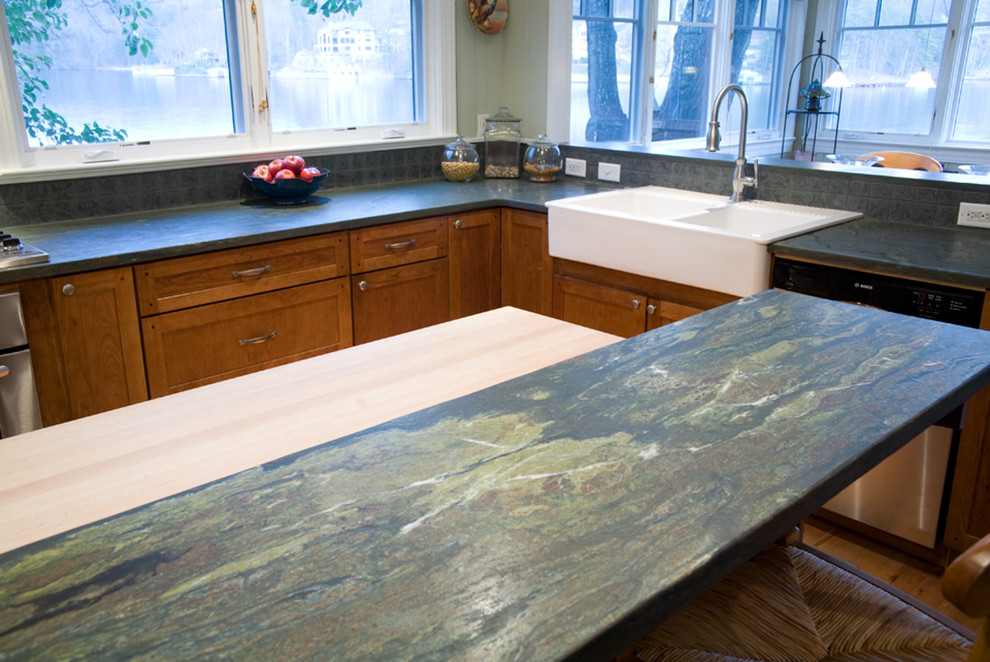 Example of a transitional medium tone wood floor kitchen design with a farmhouse sink, shaker cabinets, medium tone wood cabinets and an island