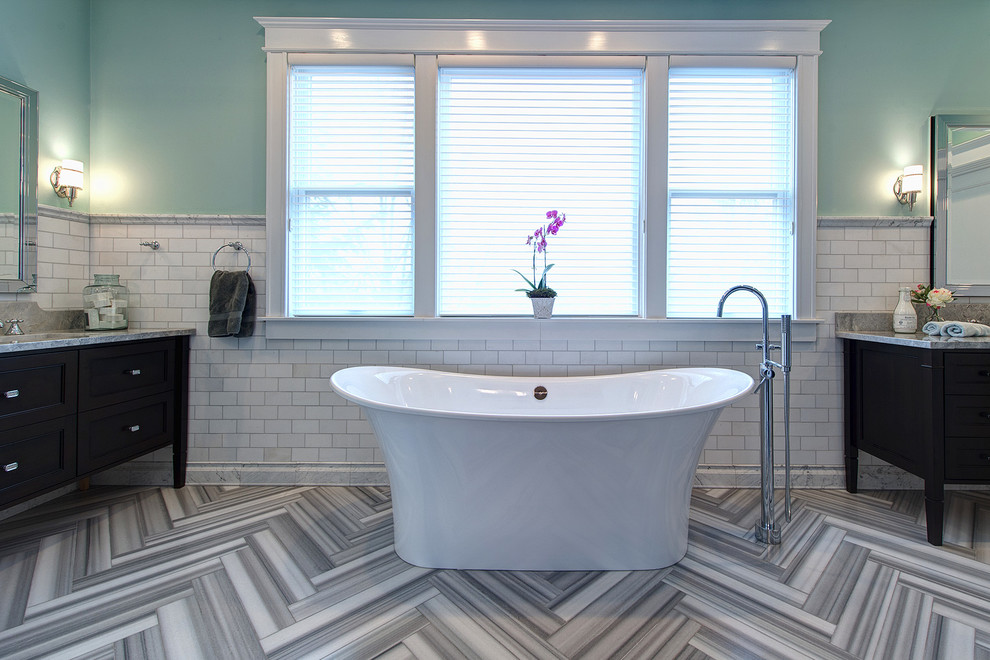 Inspiration for a large contemporary master bathroom in St Louis with a freestanding tub, white tile, blue walls, an undermount sink, grey floor, a corner shower, a hinged shower door, marble, marble floors, furniture-like cabinets, medium wood cabinets, a two-piece toilet, marble benchtops and grey benchtops.