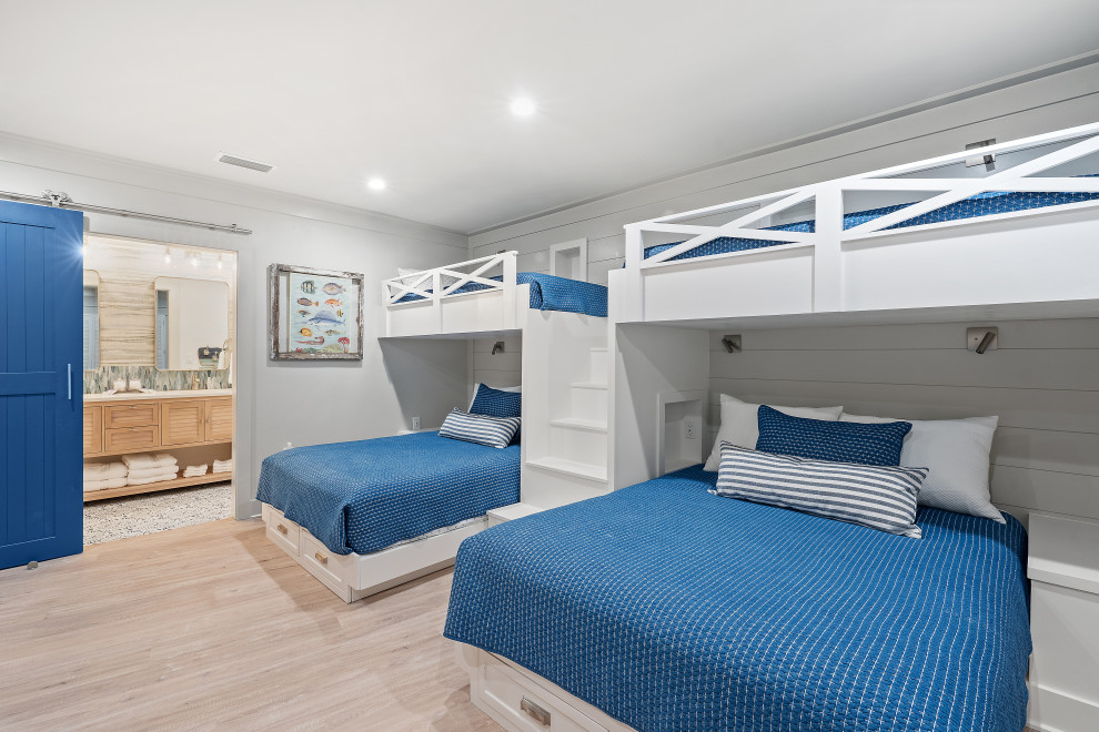 Esempio di una cameretta per bambini da 4 a 10 anni stile marinaro con pareti bianche, parquet chiaro, pavimento beige e pareti in perlinato