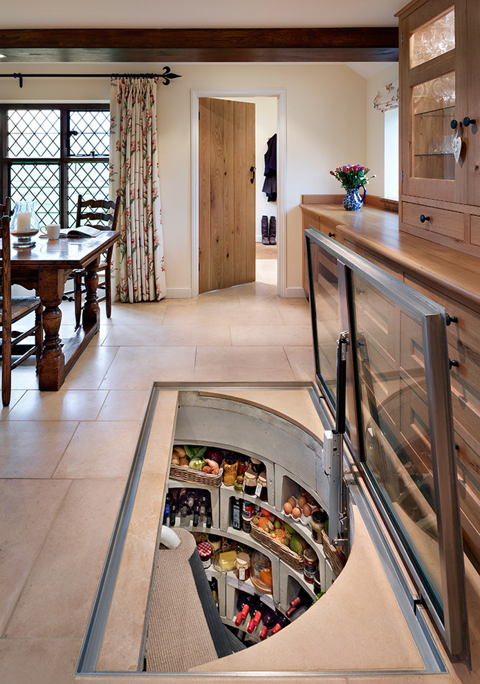 This is an example of a mid-sized country separate kitchen in Sussex with wood benchtops.
