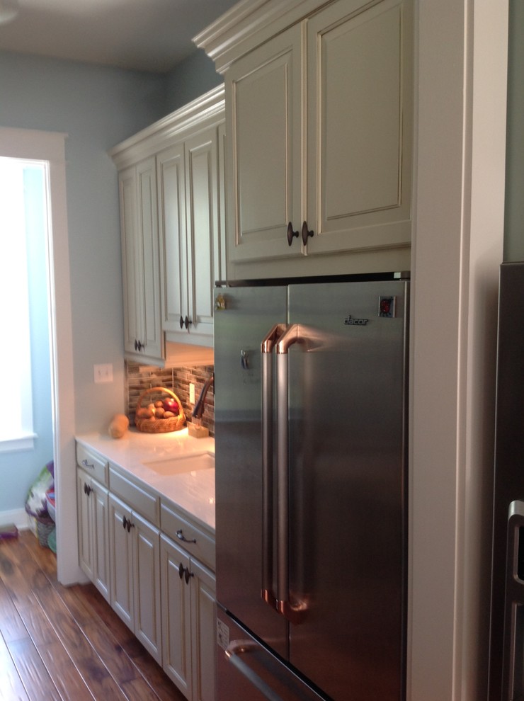 Eat-in kitchen - large transitional u-shaped porcelain tile eat-in kitchen idea in Miami with an undermount sink, flat-panel cabinets, green cabinets, quartz countertops, multicolored backsplash, mosaic tile backsplash, stainless steel appliances and an island