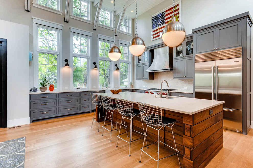 Example of a cottage l-shaped medium tone wood floor kitchen design in Denver with an undermount sink, shaker cabinets, gray cabinets, beige backsplash, stainless steel appliances and an island