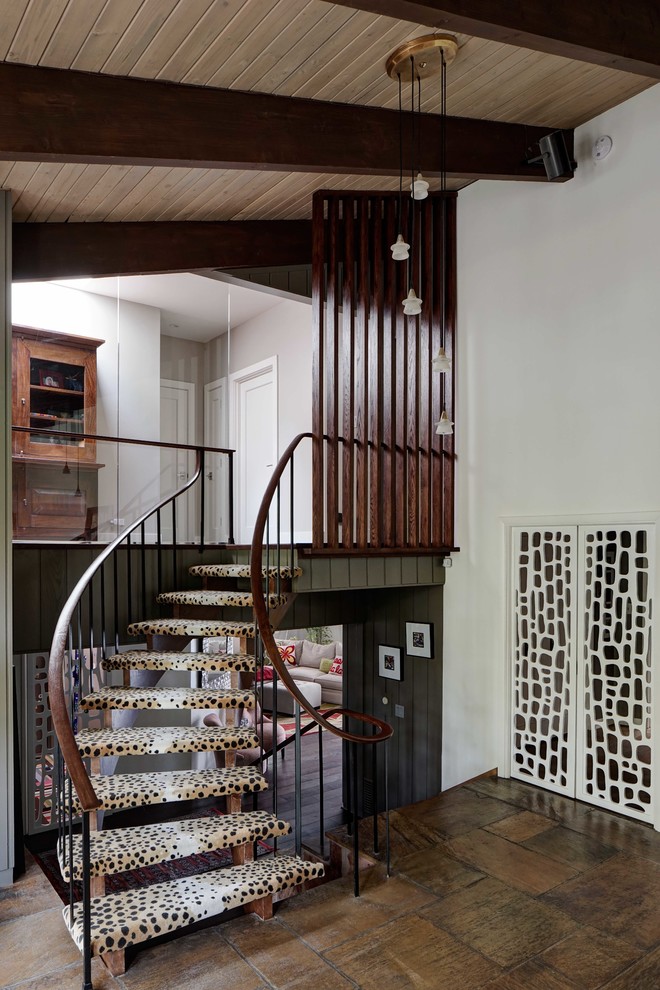 Inspiration for a midcentury carpeted curved staircase in Chicago with open risers and mixed railing.