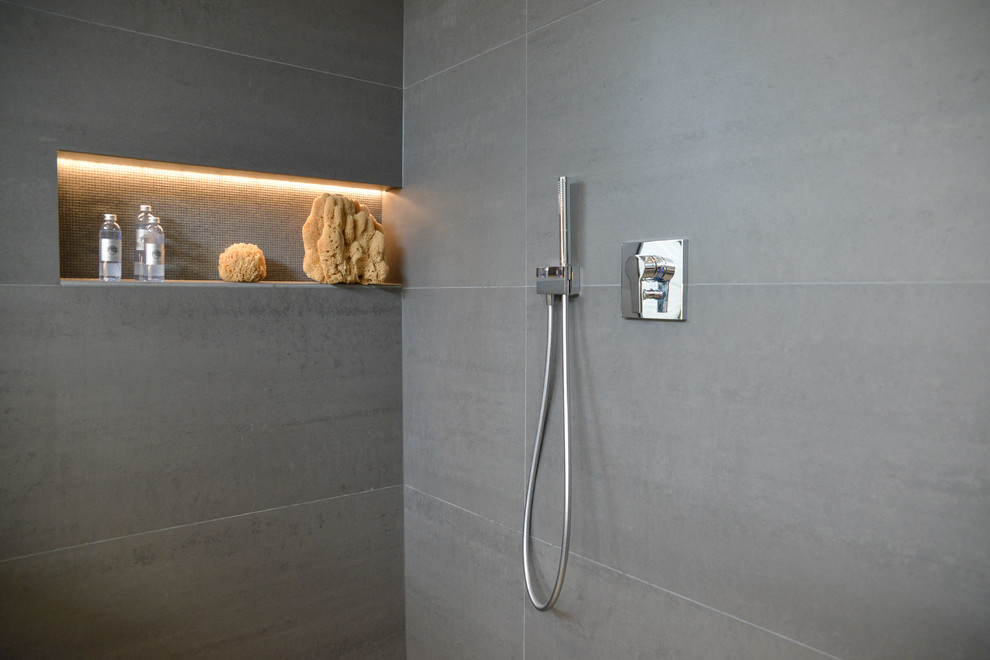 This is an example of a large contemporary shower room bathroom in Cologne with flat-panel cabinets, brown cabinets, a built-in shower, a two-piece toilet, black tiles, stone tiles, black walls, a trough sink, solid surface worktops, black floors and an open shower.