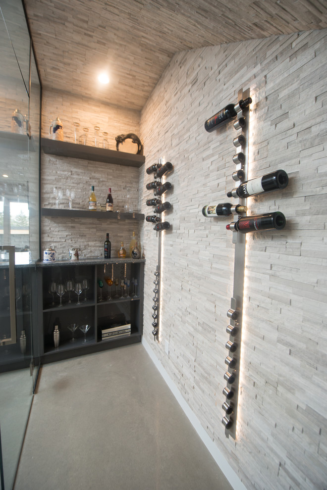 Large contemporary wine cellar in Calgary with concrete floors.