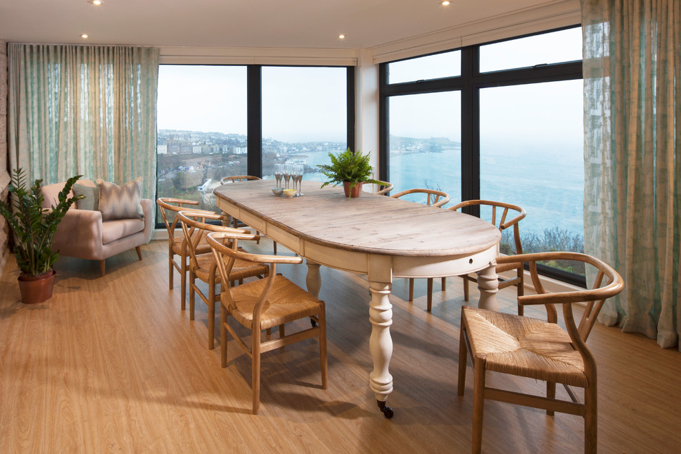 Design ideas for a beach style separate dining room in Cornwall with beige walls, light hardwood floors and beige floor.