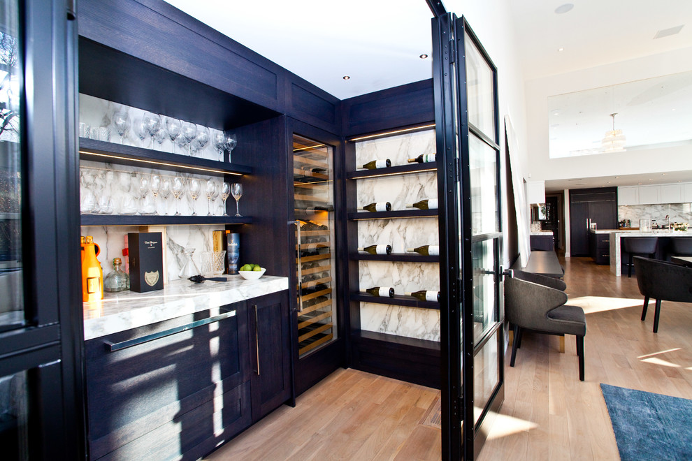 This is an example of a mid-sized transitional wine cellar in Toronto with medium hardwood floors, display racks and beige floor.