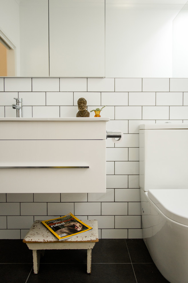 Inspiration for a mid-sized scandinavian master bathroom in Canberra - Queanbeyan with white cabinets, a drop-in tub, an open shower, a one-piece toilet, white tile, subway tile, white walls, ceramic floors, a wall-mount sink and granite benchtops.