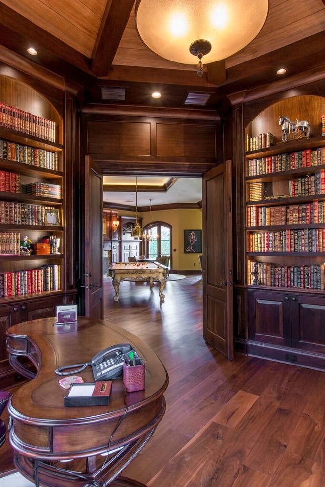 This is an example of a large contemporary study room in Tampa with beige walls, dark hardwood floors and a freestanding desk.