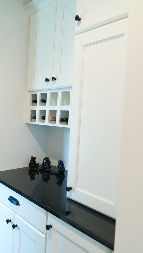 Mid-sized transitional l-shaped dark wood floor open concept kitchen photo with an undermount sink, shaker cabinets, white cabinets, granite countertops, gray backsplash, stainless steel appliances and an island
