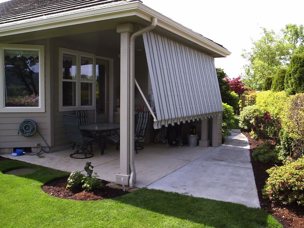 This is an example of a mid-sized traditional backyard patio in Other with concrete slab and a roof extension.