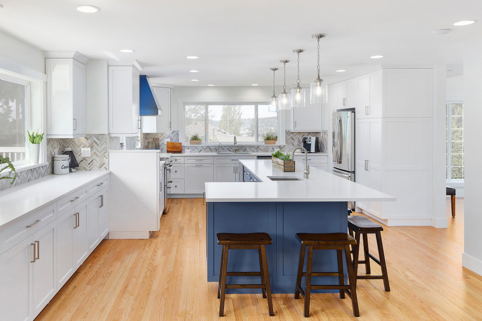 Inspiration for a large transitional l-shaped eat-in kitchen in Seattle with an undermount sink, shaker cabinets, white cabinets, quartz benchtops, multi-coloured splashback, mosaic tile splashback, stainless steel appliances, light hardwood floors, with island and yellow benchtop.
