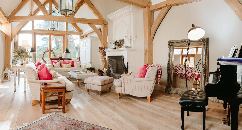 Photo of a country open concept living room in Channel Islands with a music area, beige walls and a standard fireplace.