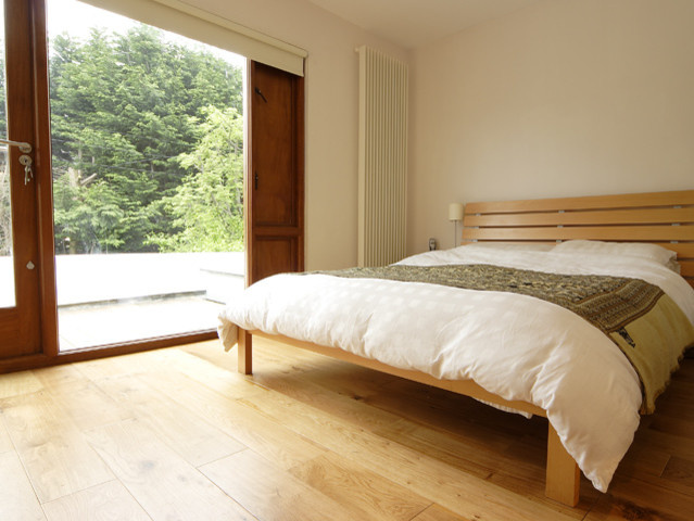 Master bedroom in Dublin with white walls and light hardwood flooring.