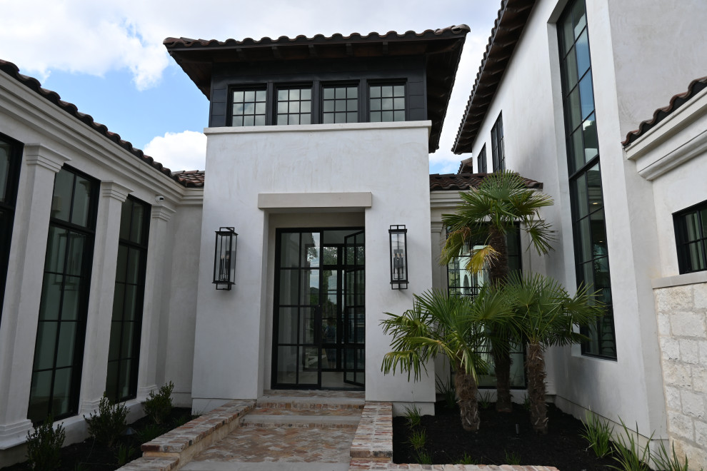 Aménagement d'une grande façade de maison métallique et blanche contemporaine à un étage avec un toit à quatre pans, un toit en tuile et un toit rouge.