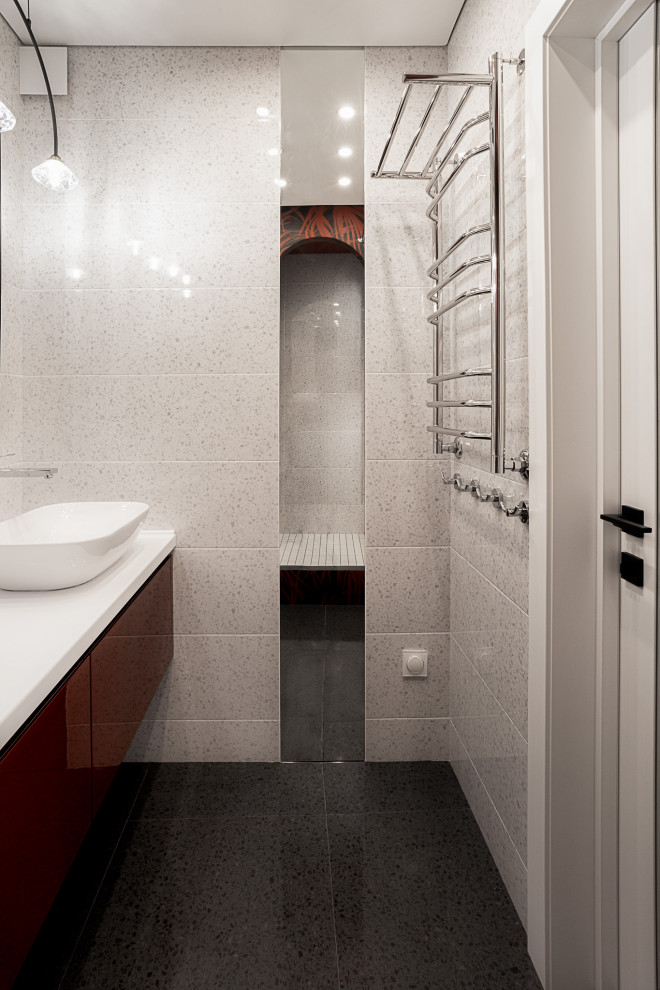 Источник вдохновения для домашнего уюта: узкая и длинная ванная комната среднего размера в современном стиле с плоскими фасадами, красными фасадами, душем в нише, раздельным унитазом, красной плиткой, керамической плиткой, белыми стенами, полом из керамической плитки, душевой кабиной, настольной раковиной, столешницей из искусственного камня, черным полом, шторкой для ванной, белой столешницей, тумбой под одну раковину, подвесной тумбой, любым потолком и панелями на части стены
