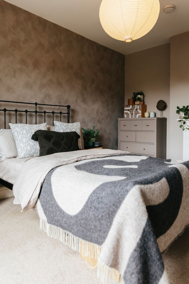 This is an example of a medium sized contemporary master bedroom in London with brown walls, carpet, a standard fireplace, a plastered fireplace surround, beige floors and a chimney breast.