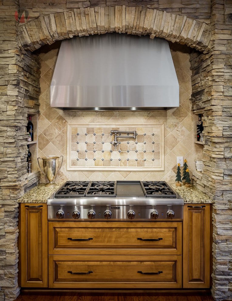 Example of a mountain style u-shaped brown floor eat-in kitchen design with an undermount sink, stainless steel appliances and an island