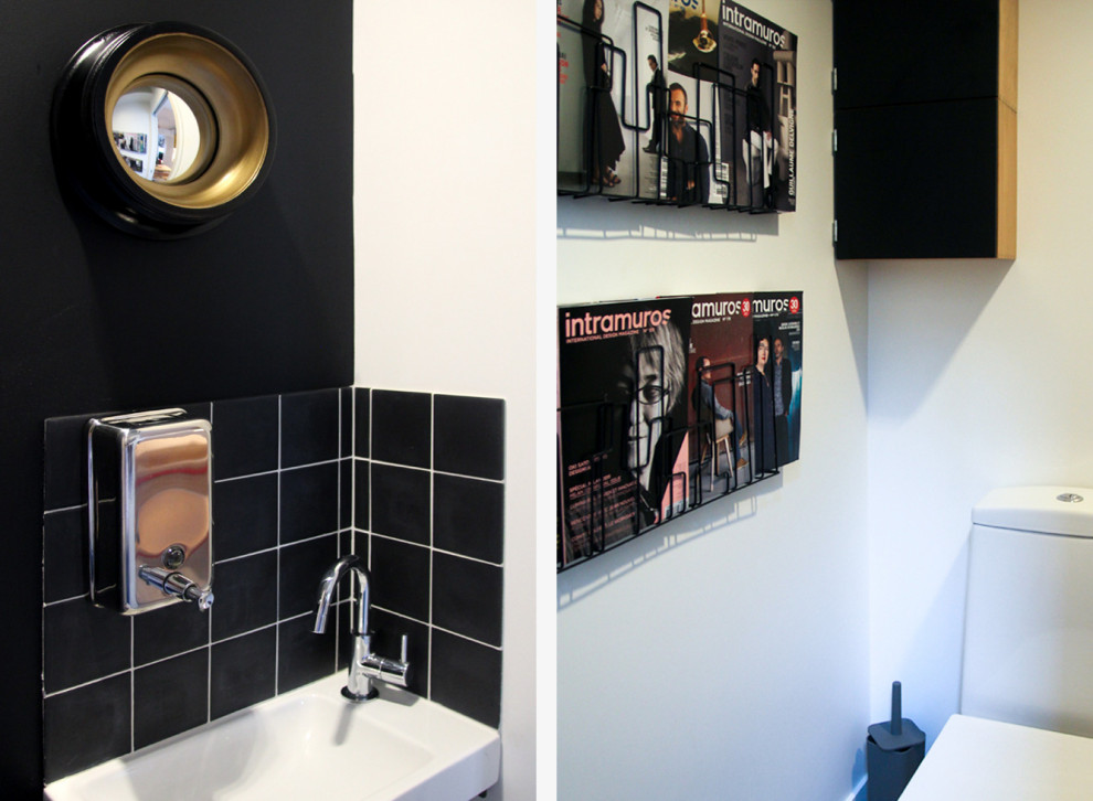Inspiration for a small industrial powder room in Paris with beaded inset cabinets, a wall-mount toilet, black tile, black walls, concrete floors, a wall-mount sink, grey floor and a floating vanity.