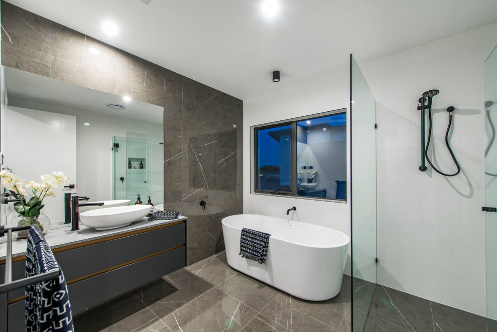 Contemporary master bathroom in Canberra - Queanbeyan with flat-panel cabinets, grey cabinets, a freestanding tub, a curbless shower, gray tile, white walls, a vessel sink, grey floor, an open shower and grey benchtops.