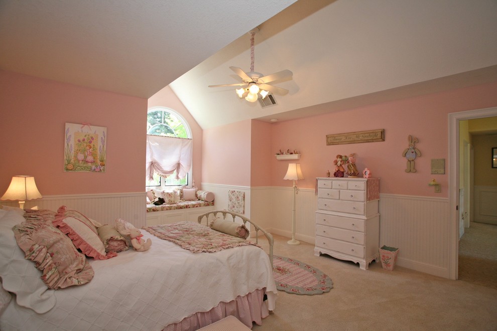 This is an example of a mid-sized traditional kids' bedroom for girls and kids 4-10 years old in San Francisco with pink walls, carpet and beige floor.