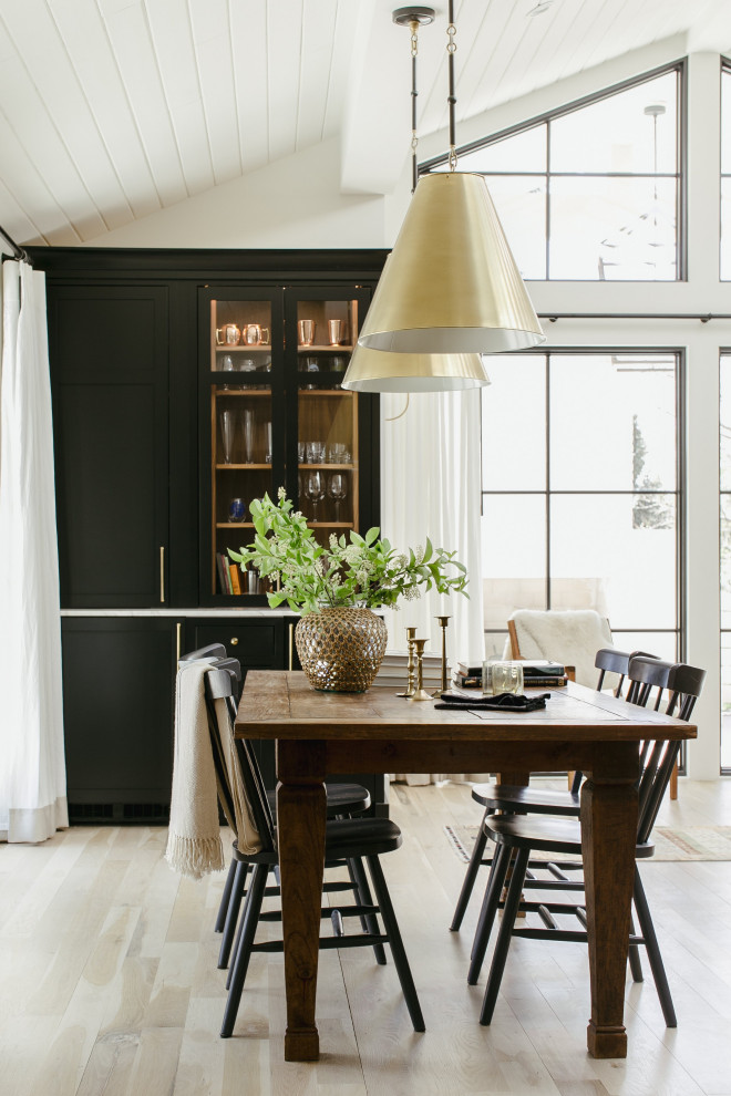 Esempio di un'ampia sala da pranzo aperta verso la cucina classica con pareti bianche, parquet chiaro e soffitto a volta