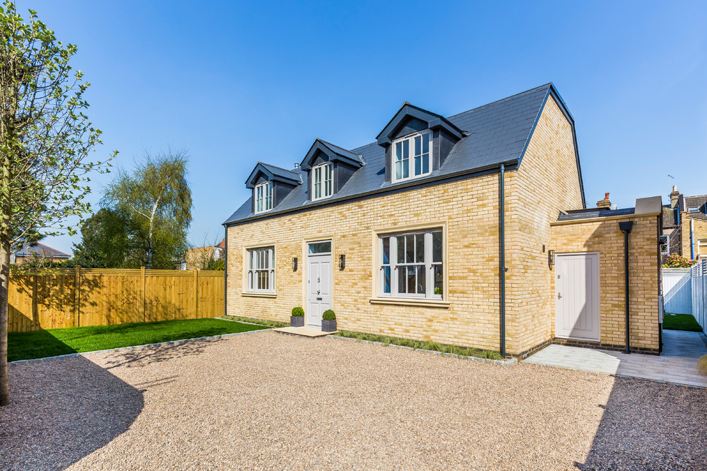 Photo of a mid-sized transitional two-storey brick yellow house exterior in London.