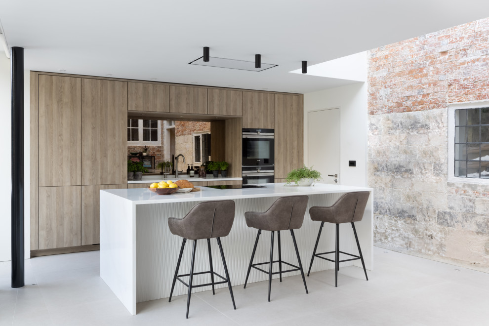 Idee per una cucina scandinava di medie dimensioni con ante lisce, ante in legno scuro, top in superficie solida, paraspruzzi a specchio, elettrodomestici neri e top bianco