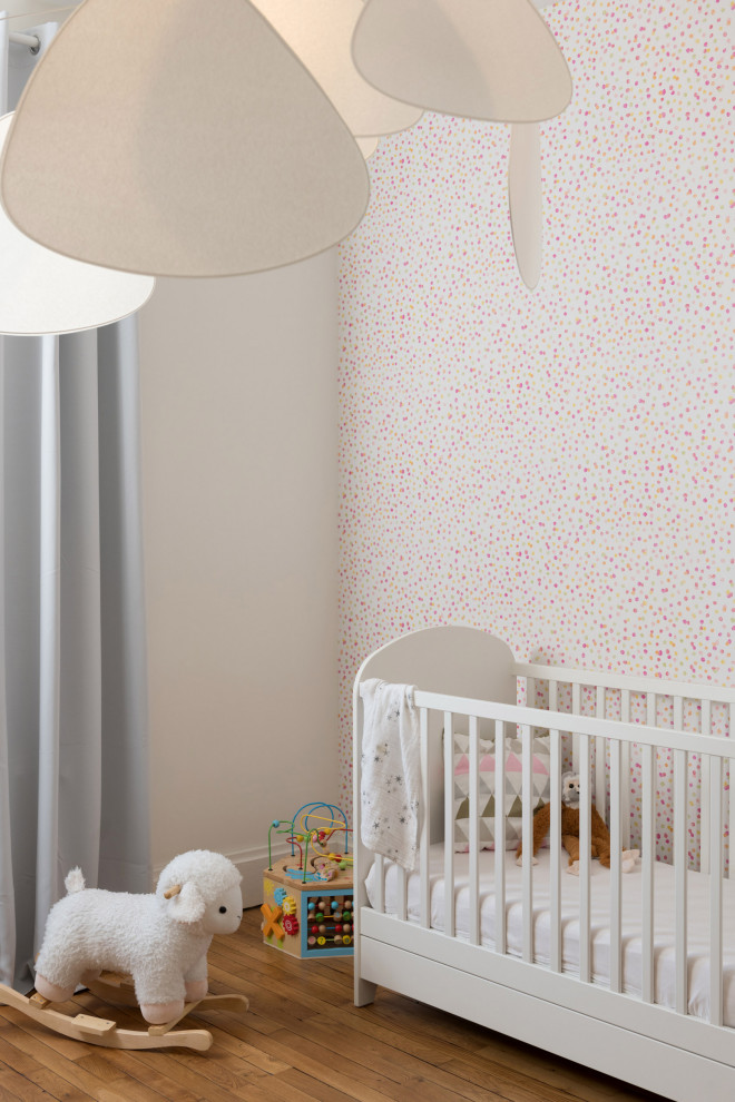 На фото: комната для малыша среднего размера в современном стиле с разноцветными стенами и паркетным полом среднего тона для девочки