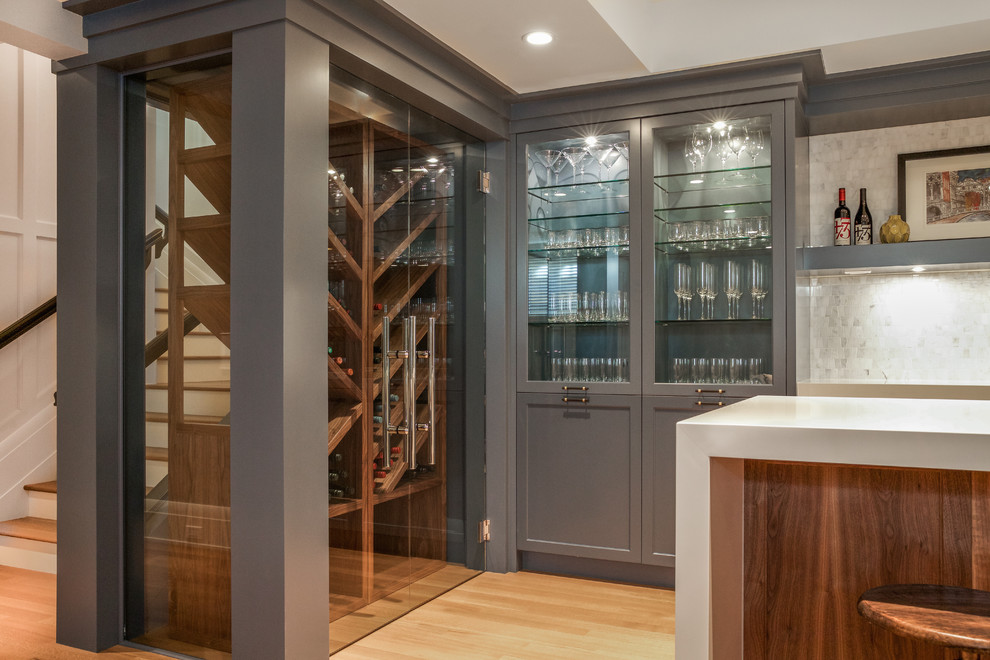 Inspiration for a mid-sized transitional wine cellar in Calgary with light hardwood floors, display racks and brown floor.