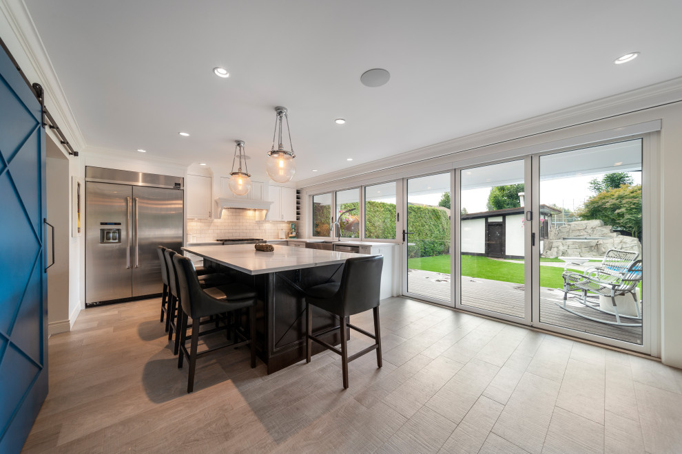 Inspiration for a transitional beige floor kitchen remodel in Vancouver with white backsplash, stainless steel appliances, an island and white countertops