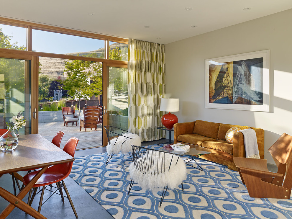 Example of a large 1950s concrete floor living room design in San Francisco with white walls, a standard fireplace and a metal fireplace