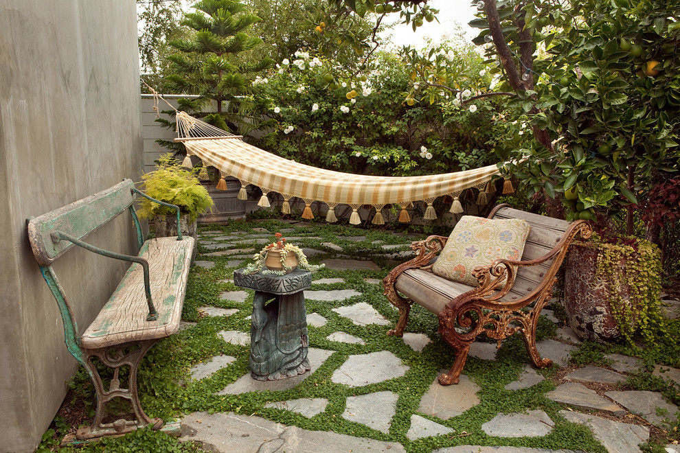 Photo of a mid-sized eclectic backyard patio in Los Angeles with natural stone pavers and no cover.