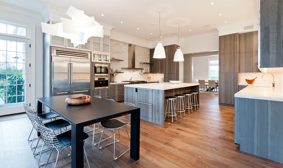 Photo of a contemporary u-shaped eat-in kitchen in New York with flat-panel cabinets and stainless steel appliances.
