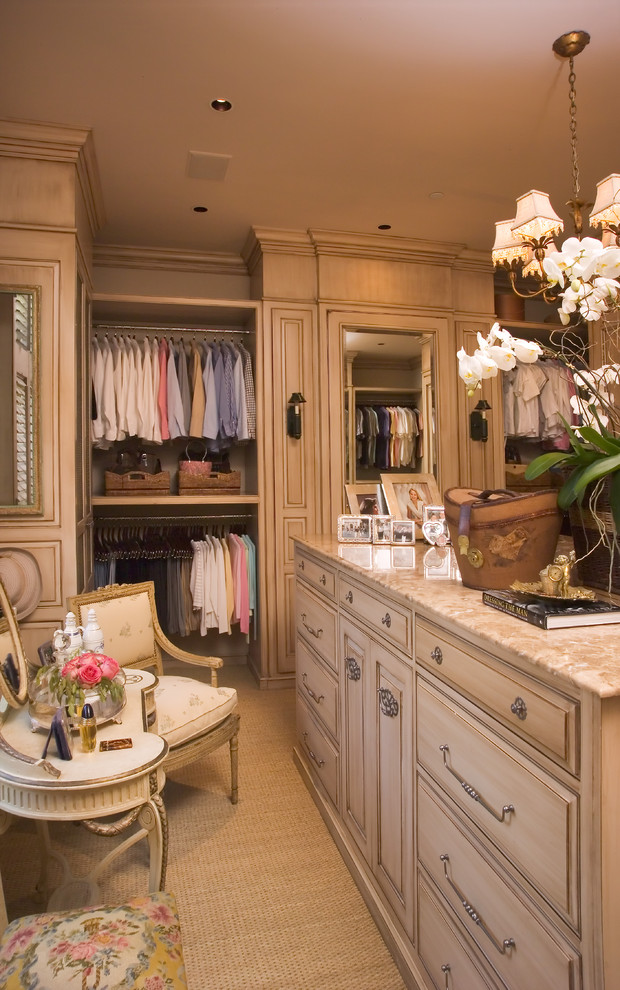 Design ideas for a traditional women's dressing room in Other with raised-panel cabinets and beige cabinets.