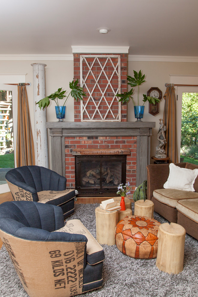 Photo of an eclectic living room in Portland with beige walls, a standard fireplace and a brick fireplace surround.