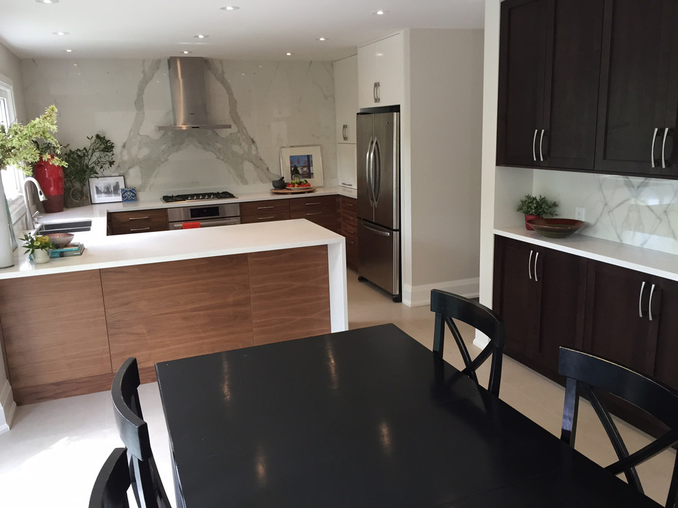 Inspiration for a mid-sized transitional porcelain tile kitchen remodel in Toronto with a double-bowl sink, recessed-panel cabinets, medium tone wood cabinets, quartz countertops, porcelain backsplash, stainless steel appliances, a peninsula and white countertops