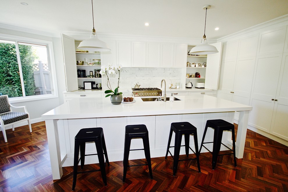 Inspiration for a large transitional l-shaped open plan kitchen in Sydney with an undermount sink, shaker cabinets, white cabinets, quartz benchtops, white splashback, stone tile splashback, stainless steel appliances, dark hardwood floors and with island.